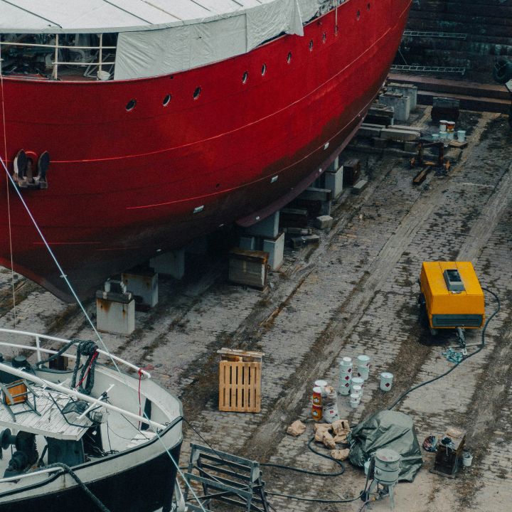 Ship with red hull in a dry dock